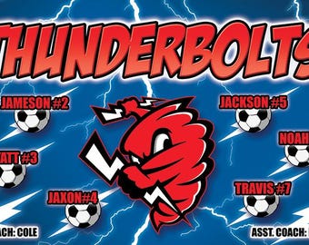 May include: A blue and white soccer team banner with the team name "THUNDERBOLTS" in red letters. The banner features a red cartoon lightning bolt mascot and the names and numbers of the players on the team. The banner also includes the names of the coaches.