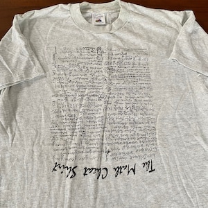 May include: A grey t-shirt with a black print of a complex mathematical equation. The text at the bottom of the shirt reads "The Math Class Sucks."