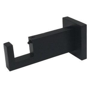 May include: Black metal bracket with a square base and a rectangular arm. The bracket is designed to hold a shelf or other object.
