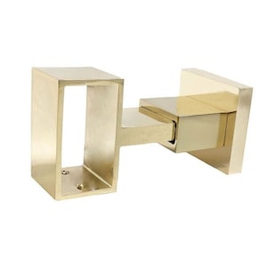 May include: A gold metal shelf bracket with a square design. The bracket has a rectangular opening on one side and a square base on the other side.