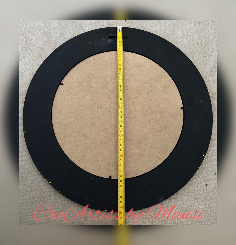 May include: A black round picture frame with a wood backing. The frame is 39 inches in diameter.