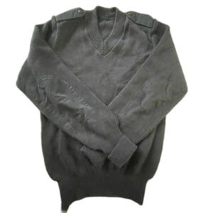 May include: A dark gray V-neck sweater with elbow patches and shoulder epaulettes. The sweater has ribbed cuffs and a ribbed hem. The fabric appears to be a soft knit material. Buttons are visible on the shoulders.