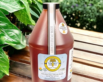 Puede incluir: Un gran bidón de plástico marrón de miel con tapa negra. La etiqueta dice "100% Pure Raw Florida Honey" y "Peso neto 2,72 kg". Etiquetas adicionales indican que la miel es de Townsend Honey Farm.