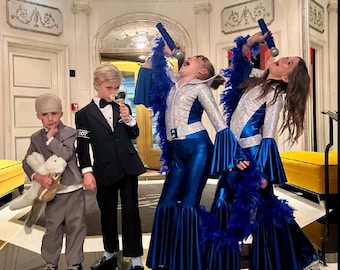 May include: Four children dressed in costumes for Halloween. Two children are dressed as disco singers in blue and silver jumpsuits with feather boas. One child is dressed as James Bond in a black tuxedo with the number 007 on the sleeve. The other child is dressed in a gray suit and holding a stuffed animal.