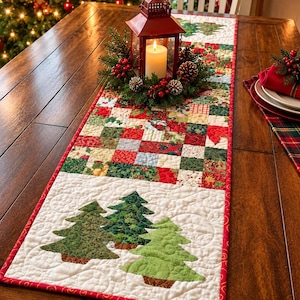 May include: A rectangular quilted table runner featuring a patchwork center of red, green, and white holiday-themed fabric squares. The ends display appliqued green Christmas trees on a white background with red border trim and stitching.