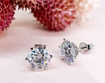 May include: A pair of silver stud earrings with large, clear, round cubic zirconia stones.