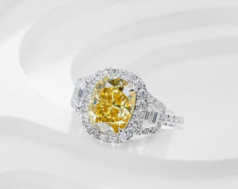 May include: A diamond ring with a large, yellow, cushion-cut center stone, surrounded by a halo of smaller diamonds. The ring has additional diamond accents on the band and side stones. The brand name "GIGAEWE" is visible in the upper left corner.