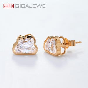 May include: A pair of gold-tone cloud-shaped earrings with clear cubic zirconia stones.
