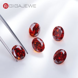 Könnte beinhalten: Fünf rote, ovale Edelsteine auf einer weißen Oberfläche. Die Edelsteine sind facettiert und haben einen hohen Glanz.