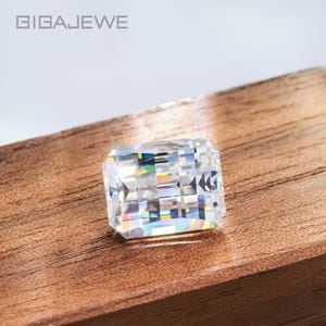 Peut inclure: Une pierre précieuse transparente de forme carrée avec une taille facetée, reposant sur une surface en bois.