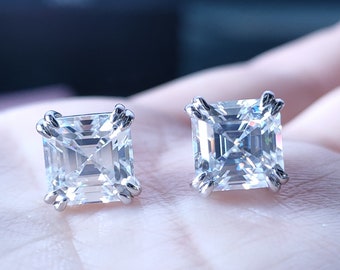 May include: A pair of silver earrings with square-shaped clear cubic zirconia stones.