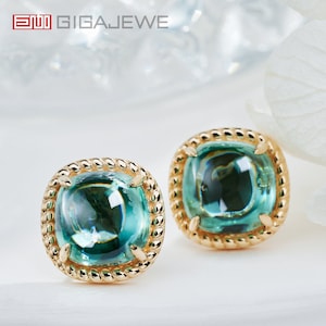 May include: A pair of gold earrings with a square green gemstone in each. The gemstones have a faceted design and are set in a gold rope-like border.