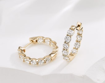 May include: A pair of gold hoop earrings with a row of small, clear diamonds around the edge of each hoop.