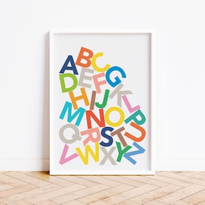 May include: A white framed print featuring a colourful alphabet design. The letters are arranged in a random pattern and are in various colours, including red, blue, green, yellow, orange, and pink.