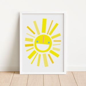 May include: A white framed print of a yellow sun with a smiling face and yellow rays. The sun is on a white background.