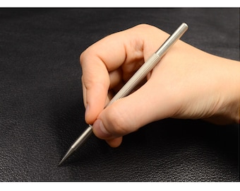May include: A silver leather crafting tool with a pointed tip and a textured handle.