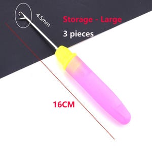 May include: A latch hook tool with a silver metal hook, a yellow collar, and a translucent pink handle. The tool measures 16 cm in length with a 4.5 mm hook size. The text Storage - Large and 3 pieces is visible in the image.