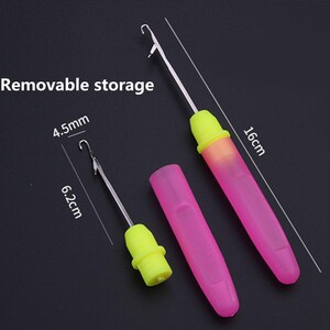 May include: A crochet hook with a removable storage handle, featuring a pink translucent cap and a bright yellow grip. The tool measures 16 cm in total length, with a 6.2 cm hook component and a 4.5 mm hook size. The text Removable storage is visible.