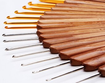 May include: A set of 15 bamboo crochet hooks with gold and silver tips. The hooks are arranged in a fan shape, with the largest hook at the top and the smallest hook at the bottom. The hooks are numbered 2.00, 2.25, 2.50, 2.75, 3.00, 3.25, 3.50, 3.75, 4.00, 4.50, 5.00, 5.50, 6.00, 6.50, 7.00.