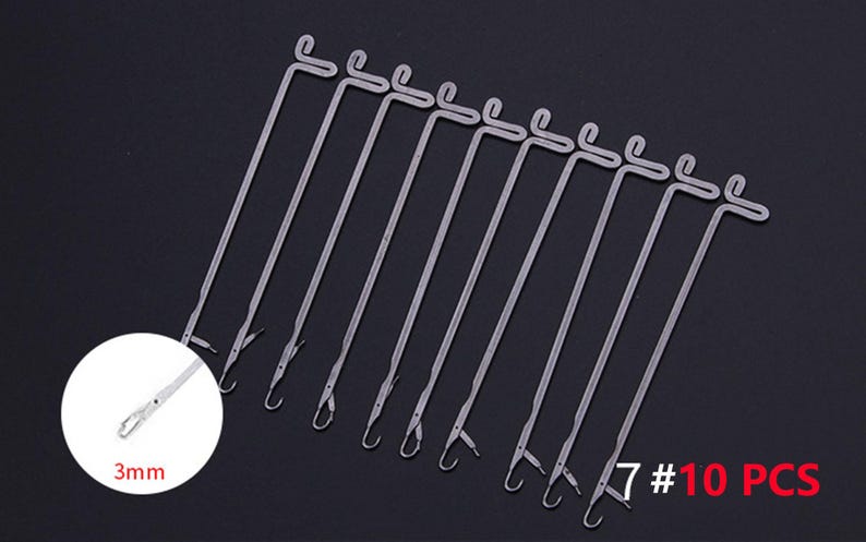 May include: A set of 10 silver-colored metal knitting machine needles, each featuring a latch hook mechanism at the tip and a looped handle at the top. A circular inset shows a close-up of the needle tip with a 3mm measurement label.