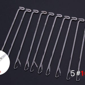 May include: A set of 10 silver-colored metal knitting machine needles, each featuring a latch hook mechanism at the tip. A circular inset shows a magnified view of the hook with the text 4mm, and the text 5# 10 PCS is visible in red.
