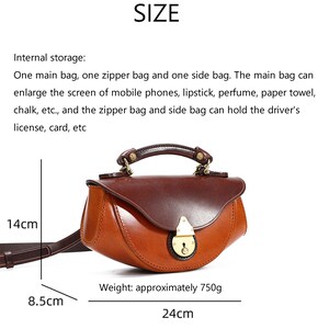 May include: A brown leather satchel handbag with a brass lock and handle. The bag measures 14 inches in length, 8.5 inches in height, and 24 inches in width. It weighs approximately 750 grams.
