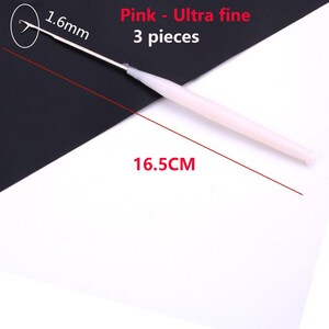 May include: A pink ultra fine crochet hook measuring 1.6mm at the tip and 16.5cm in total length. The set includes 3 pieces. The tool features a slender metal hook attached to a smooth, light pink plastic handle for crafting and needlework.