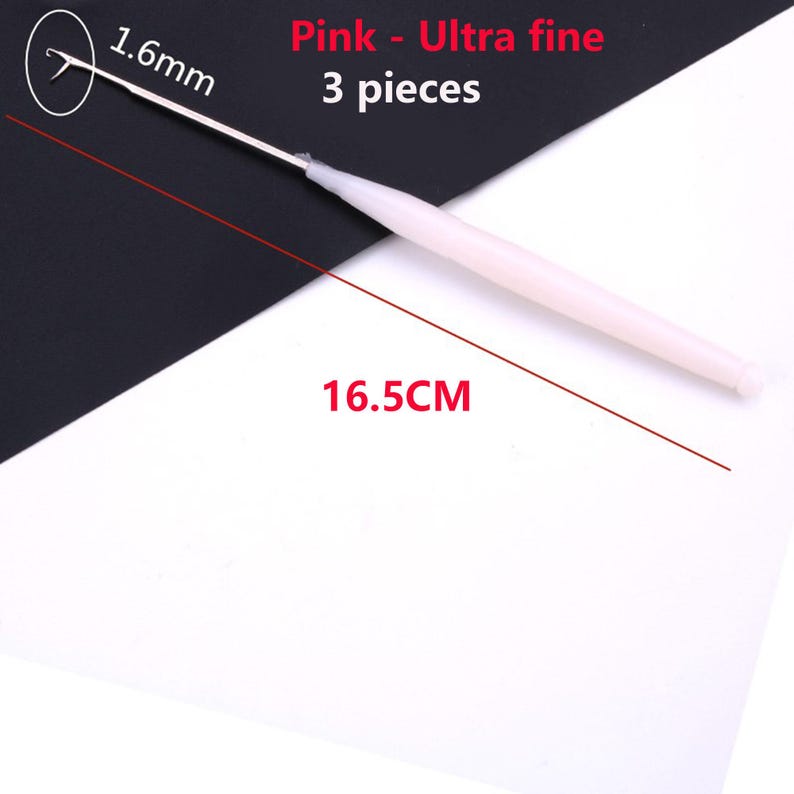 May include: A pink ultra fine crochet hook measuring 1.6mm at the tip and 16.5cm in total length. The set includes 3 pieces. The tool features a slender metal hook attached to a smooth, light pink plastic handle for crafting and needlework.