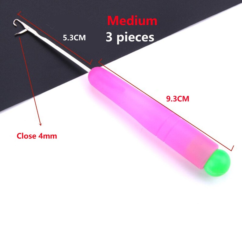 May include: A medium crochet hook with a pink handle and a bright green end cap. The metal hook section measures 5.3 cm, the handle measures 9.3 cm, and the hook opening is 4 mm. The text Medium 3 pieces is visible in the image.