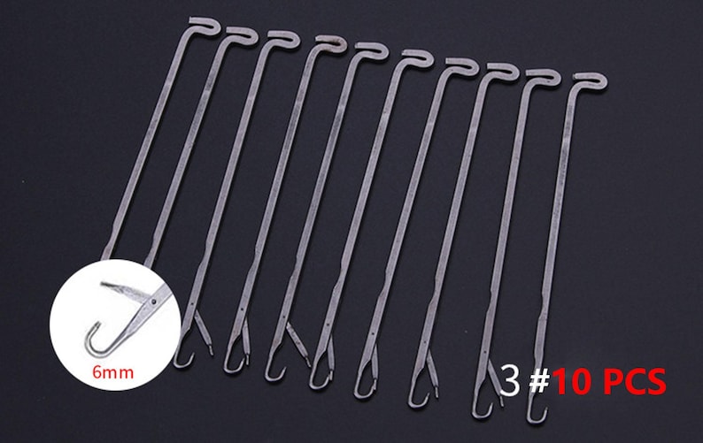 May include: A set of 10 silver-colored metal knitting machine needles, each featuring a hooked end and a latch mechanism. A circular inset shows a close-up of the needle tip with the text 6mm, while the text 3 #10 PCS appears in the corner.