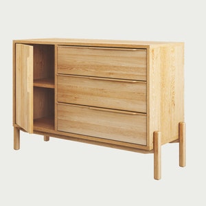 May include: A light wood cabinet with three drawers and a door that opens to reveal a shelf. The cabinet has a modern design with simple lines and a natural finish.
