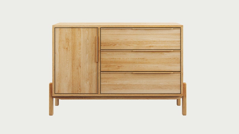 May include: A light wood dresser with three drawers and a cabinet door. The dresser has a simple design with a light wood finish and brass hardware.
