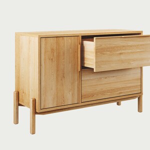 May include: A light wood cabinet with two drawers and a door. The top drawer is open, revealing the wood interior.