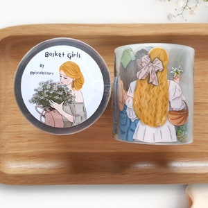 Könnte beinhalten: Zwei Rollen Washi-Tape mit Illustrationen von Frauen mit Blumen und einem Korb. Das Band ist mit "Basket Girls" von @piracle.hers beschriftet.