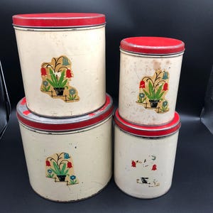 Set of 4 vintage metal canisters with lid and a flower motif on the front, lids are red