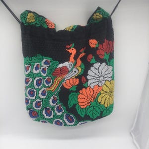 Cartera de mano vintage con diseño de pavo real y cuentas, con asas y cordón, y un pequeño bolsillo en el interior. Fabricada en Hong Kong en los años 70.