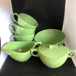 Set of 9 Avocado green Melmac dishware, 3 cups, 3 small bowls and a cream and sugar bowl with lid