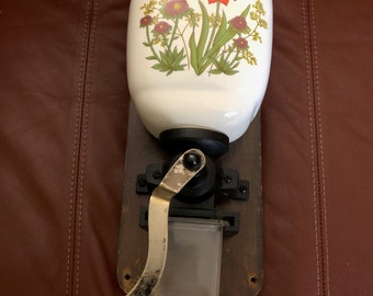 Beautiful vintage wall mount coffee grinder with floral design on ceramic