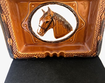 Hermosa bandeja de baratijas de cerámica con una cabeza de caballo en la foto.