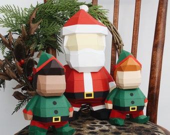 May include: A papercraft set of Santa Claus and two elves. Santa is wearing a red suit with a white beard and a white hat. The elves are wearing green suits with red hats. They are all standing on a leopard print surface.