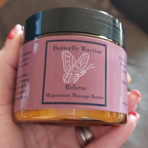 May include: A jar of yellow magnesium massage butter with a pink label that says "Butterfly Warrior Relieve Magnesium Massage Butter". The label also features a butterfly illustration.