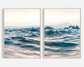 May include: Two framed prints of a close-up view of ocean waves with a mountain range in the background. The water is a deep blue with whitecaps and the sky is a light blue.