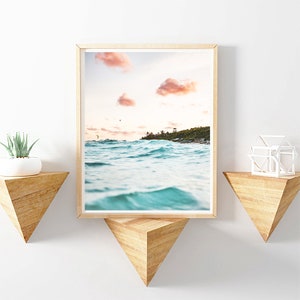 May include: A framed photograph of a beach scene with turquoise water and pink clouds in the sky.