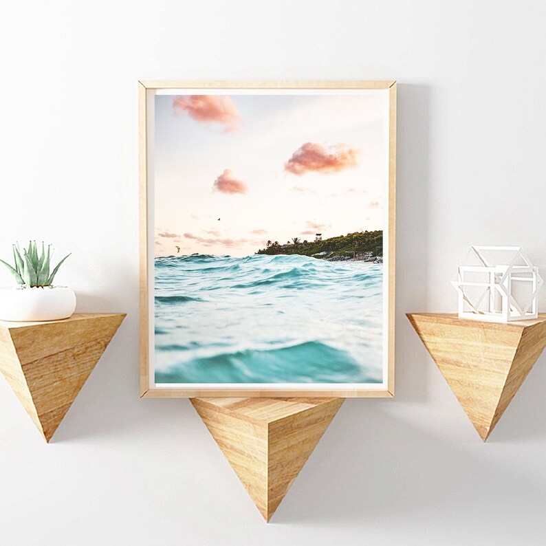 May include: A framed photograph of a beach scene with turquoise water and pink clouds in the sky.