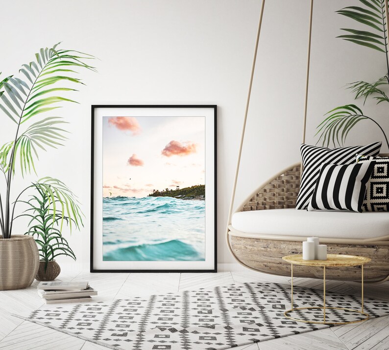 May include: A framed photograph of a beach scene with turquoise water and pink clouds in the sky.