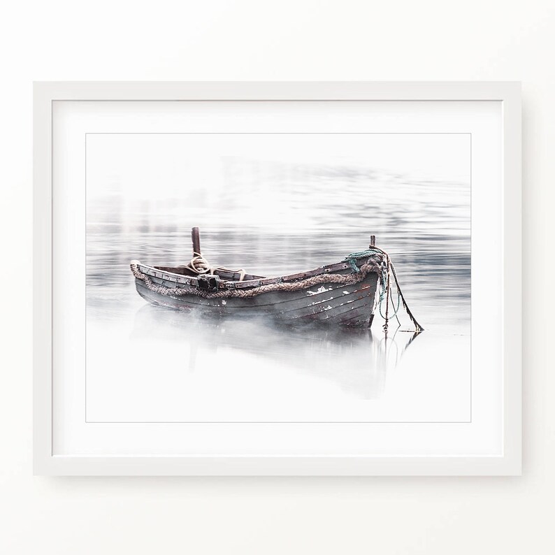 May include: A weathered wooden boat sits in a misty lake, with a rope and net trailing in the water.