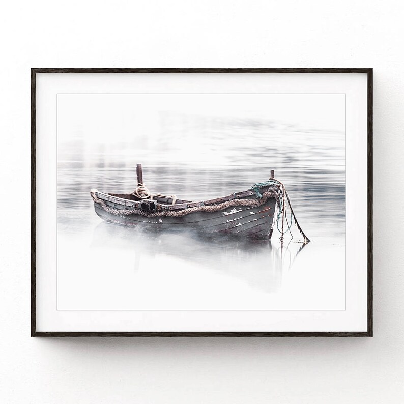 May include: A weathered wooden rowboat sits in a misty lake. The boat is tied to a dock with rope. The water is calm and the sky is overcast.