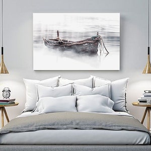 May include: A weathered wooden boat sits in a misty lake, with a soft, muted color palette. The boat is tied to a dock with ropes, and the water is calm and still.