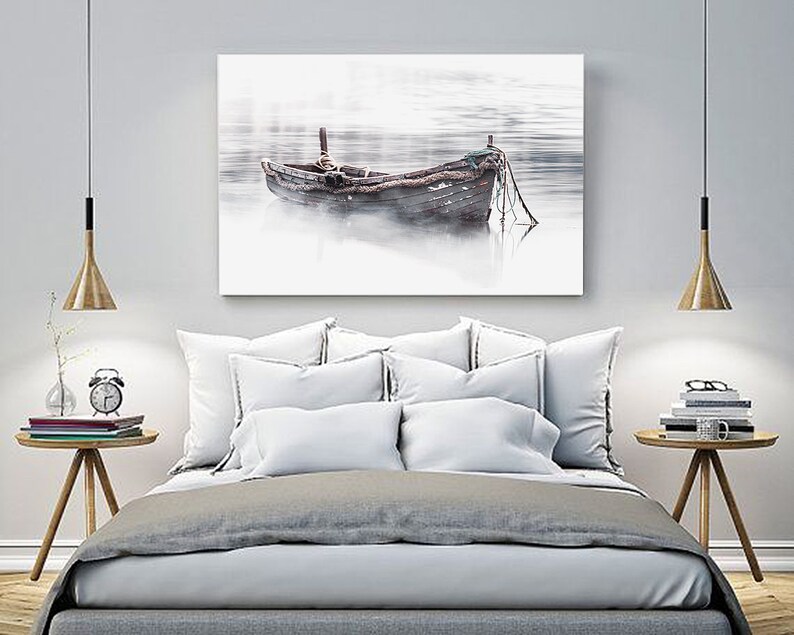 May include: A weathered wooden boat sits in a misty lake, with a soft, muted color palette. The boat is tied to a dock with ropes, and the water is calm and still.