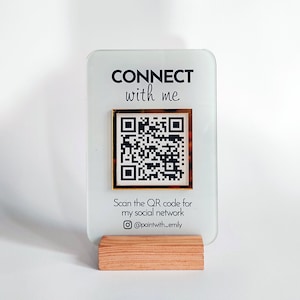 May include: A white acrylic sign with gold trim and a black QR code. The sign reads "CONNECT with me" and "Scan the QR code for my social network @paintwith_emily".